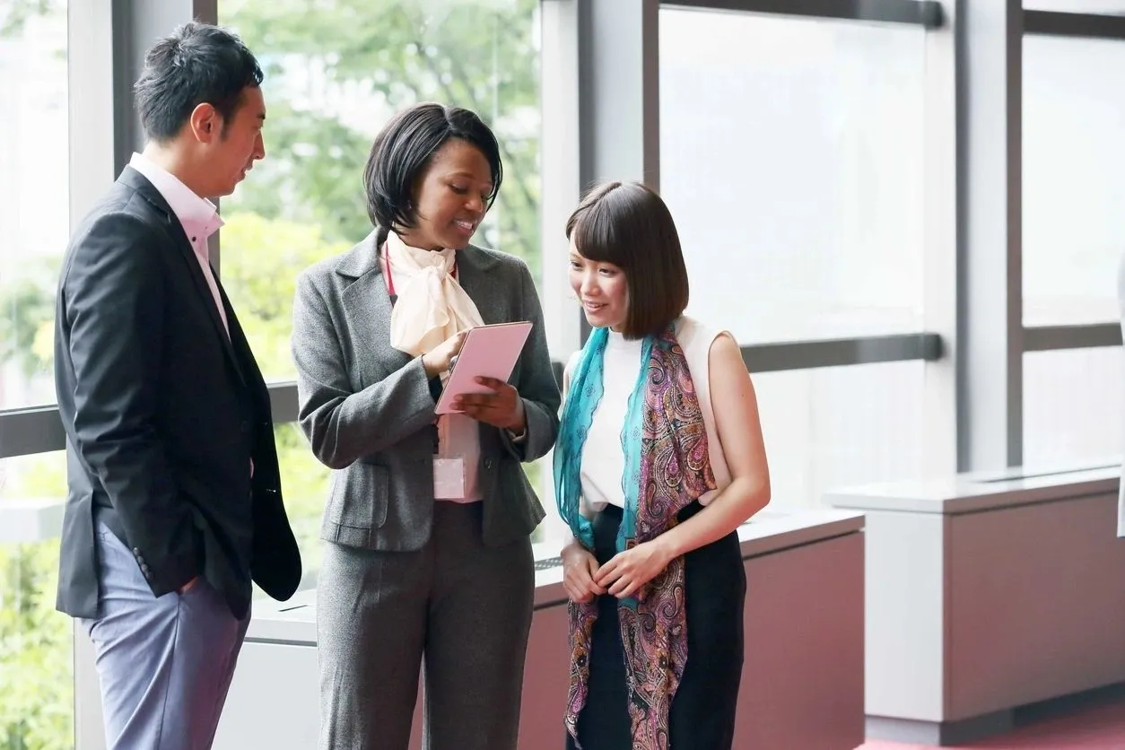 Three people standing around talking to each other.